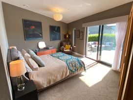 A bedroom with a bed and armchair at Woodcroft in Pwllheli