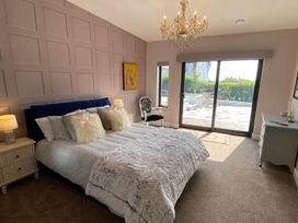 A bedroom with a bed and sliding door access to outdoor area at Woodcroft in Pwllheli