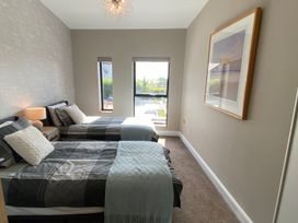 A bedroom with two beds and a window at Woodcroft in Pwllheli