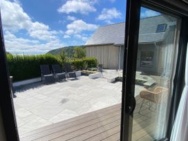 An outdoor patio with furniture and planters at Woodcroft in Pwllheli