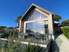 A house with a patio and seating area at Woodcroft in Pwllheli