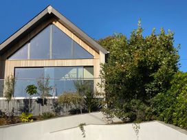 A modern house with large windows and a garden at Woodcroft Pwllheli
