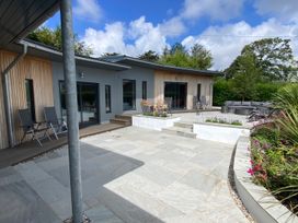 An outdoor area with a house and seating at Woodcroft in Pwllheli