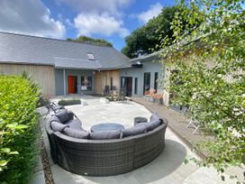 An outdoor seating area with a sofa and table at Woodcroft in Pwllheli