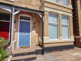 A front entrance with a blue door and brick wall at Coral Villa in Bridlington
