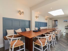 A dining room with a long table and seating at Coral Villa in Bridlington