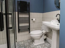 A bathroom with sink, toilet, shower and towel rail at Coral Villa in Bridlington