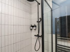 A shower with a black showerhead and soap dispenser at Coral Villa in Bridlington