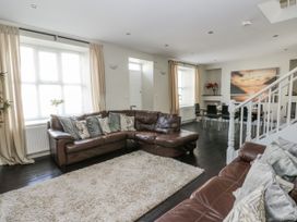 A living room with a sofa and dining area at Station Hall in Cilgerran