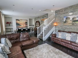 A living room with a sofa and dining area at Station Hall in Cilgerran