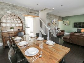 A dining room with a table set for meals at Station Hall in Cilgerran