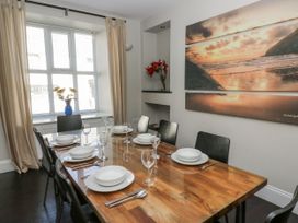 A dining room with a wooden table set for dinner at Station Hall in Cilgerran