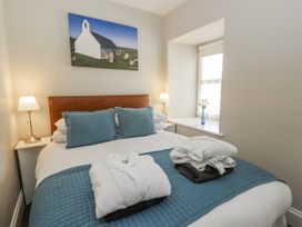 A bedroom with a bed and lamps at Station Hall in Cilgerran