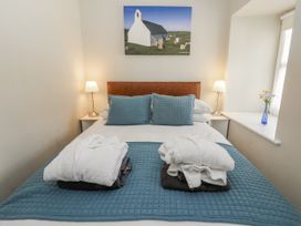 A bedroom with a bed and lamp at Station Hall in Cilgerran