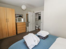 A bedroom with a wardrobe and chest of drawers at Station Hall in Cilgerran