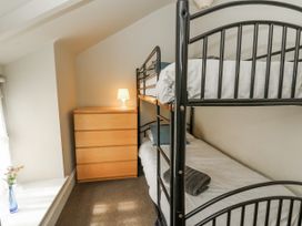 A bedroom with a bunk bed and a dresser at Station Hall in Cilgerran