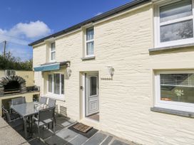 A house exterior with a patio set and an outdoor fireplace at Station Hall in Cilgerran