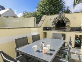 An outdoor patio with a table and chairs at Station Hall in Cilgerran