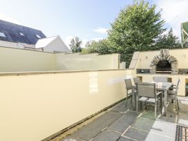 A garden area with a table and chairs and an outdoor grill at Station Hall in Cilgerran