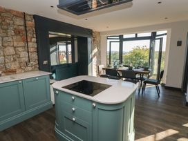 A kitchen with a cooking island and a dining area at 9 Brython Place Tenby
