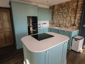 A kitchen with cabinets and appliances at 9 Brython Place Tenby