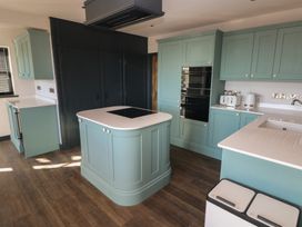 A kitchen with cabinets and an island at 9 Brython Place Tenby