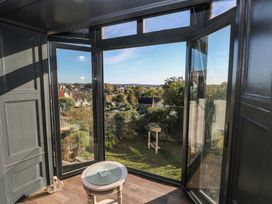 A sunroom with a table and window view at 9 Brython Place Tenby
