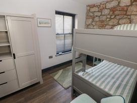 A bedroom with a bunk bed and wardrobe at 9 Brython Place Tenby