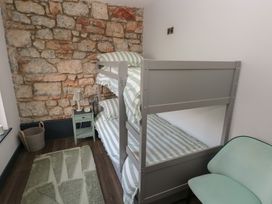 A bedroom with a bunk bed and a nightstand at 9 Brython Place in Tenby