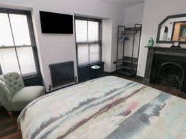 A bedroom with a bed and a sofa at 9 Brython Place Tenby