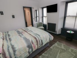 A bedroom with a bed and television at 9 Brython Place in Tenby