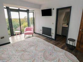 A bedroom with a bed and chair at 9 Brython Place Tenby