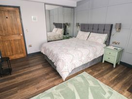 A bedroom with a bed and nightstands at 9 Brython Place Tenby
