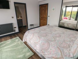 A bedroom with a bed, wardrobe, and a TV at 9 Brython Place in Tenby