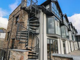 An exterior view of a building with a spiral staircase and glass windows at 9 Brython Place Tenby