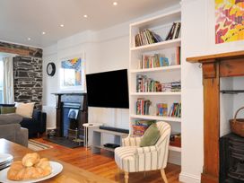A living room with a television and bookshelf at 2 Glyddins 1910 in Rock