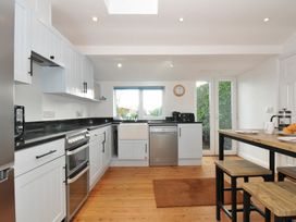 A kitchen with cabinets, stove, and wooden table at 2 Glyddins 1910 in Rock