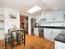 A kitchen with a table and stools at 2 Glyddins 1910 in Rock
