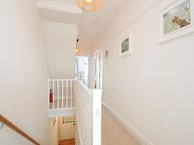 A hallway with a staircase and framed artwork at 2 Glyddins 1910 in Rock
