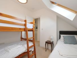 A bedroom with a bunk bed and a single bed at 2 Glyddins 1910 Rock