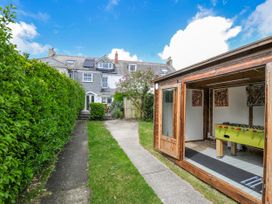 A garden with a pathway and a shed containing a foosball table at 2 Glyddins 1910 Rock