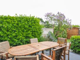 A garden with wooden furniture and greenery at 2 Glyddins 1910 in Rock