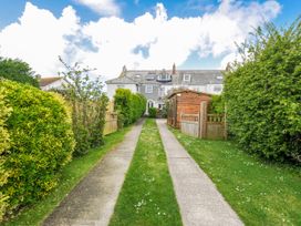 A pathway leading to a house with a shed in the garden at 2 Glyddins 1910 Rock