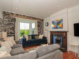 A living room with a blue sofa and a fireplace at 2 Glyddins 1910 in Rock