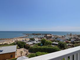 A view of a beach and sea with boats and houses at 3 Harbour Heights in Lyme Regis