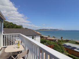 A balcony with a table and chairs overlooking the sea at 3 Harbour Heights Lyme Regis