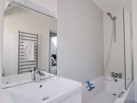 A bathroom with a sink, bathtub, and towel rack at 3 Harbour Heights in Lyme Regis