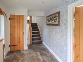 A hallway with staircase and wooden door at Haystacks in Troutbeck