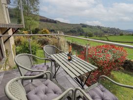 An outdoor seating area with a table and chairs at Haystacks in Troutbeck