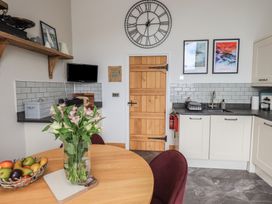 A kitchen with table and flowers at Haystacks in Troutbeck